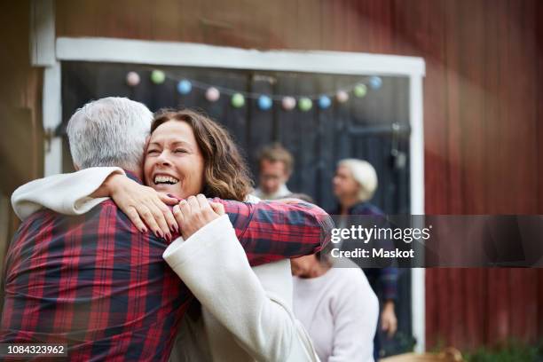 happy mature woman embracing man while standing at farm - chemise à carreaux photos et images de collection