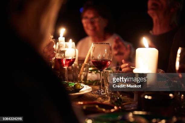 friends enjoying candlelight harvest dinner at table in party - kerzenschein stock-fotos und bilder