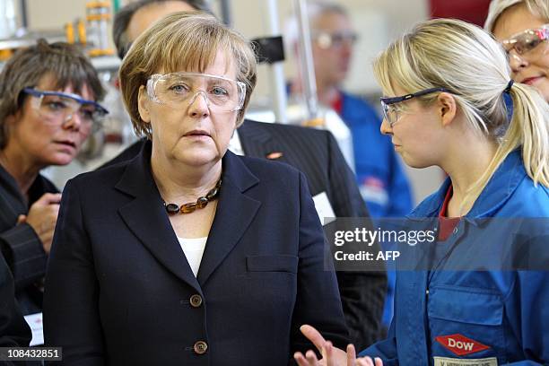 German Chancellor Angela Merkel talks with employee Vivian Hernandez-Vega on January 27, 2011 as she visits the laboratory for chemical engineering...
