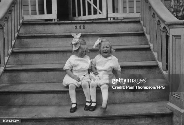 Jan and Marjorie, the twin daughters of writer Ellis Parker Butler, crying on the steps of their home in 1911.