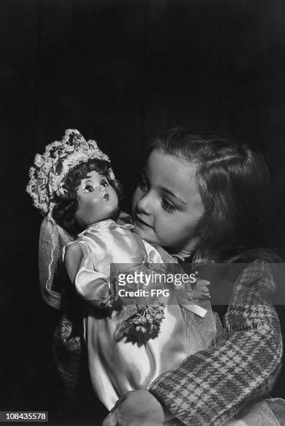 Girl holding a doll at the world's largest doll exhibition held at the Hearns Auditorium in New York in the 1940's.