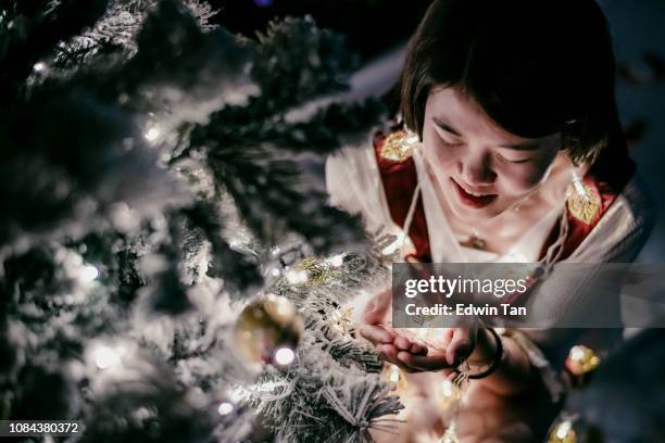 eine asiatische chinesische weibliche hand hält einen weihnachtsbaum licht - s christmas festival stock-fotos und bilder