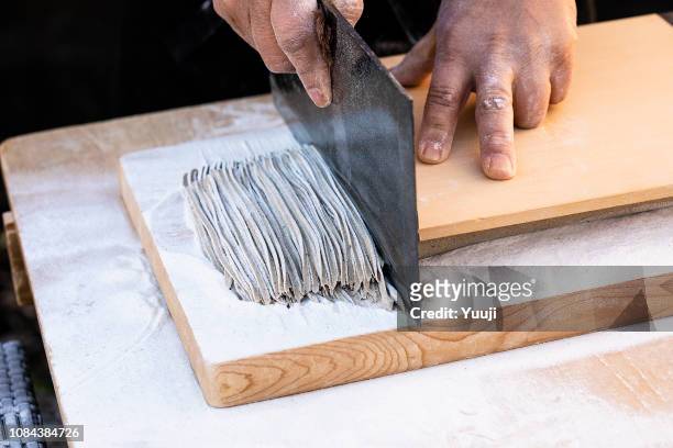 japanese soba made by professional craftsmen. put the water in buckwheat flour, stretch the dough with a noodle stick and cut it up with a kitchen knife. - buckwheat stock pictures, royalty-free photos & images
