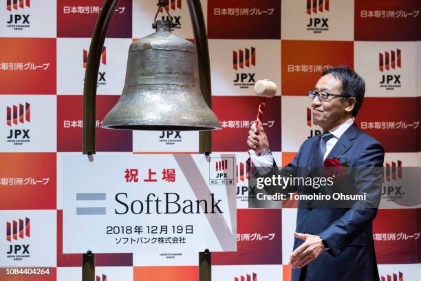 SoftBank Corp. Chief Executive Officer Ken Miyauchi hits a bell during a ceremony for the company's listing at the Tokyo Stock Exchange on December...