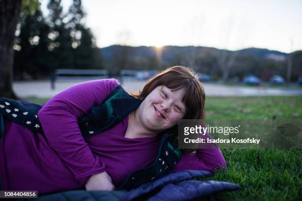 Woman with Down Syndrome relaxes outside.