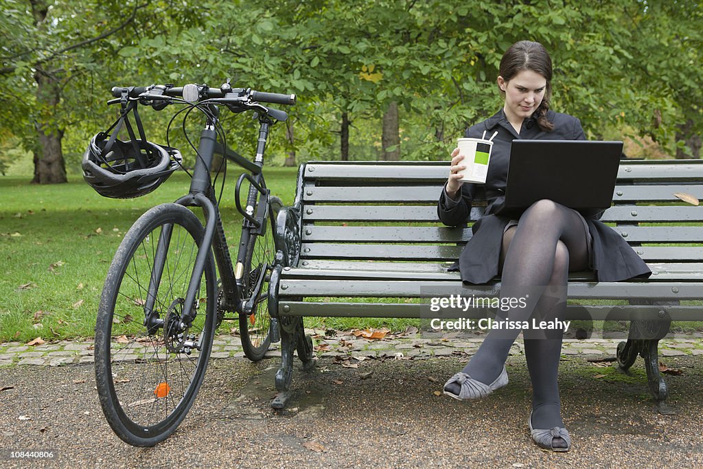 Woman looking at laptop and eating lunch