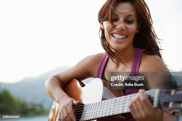 frau spielt gitarre - saiteninstrument spielen stock-fotos und bilder