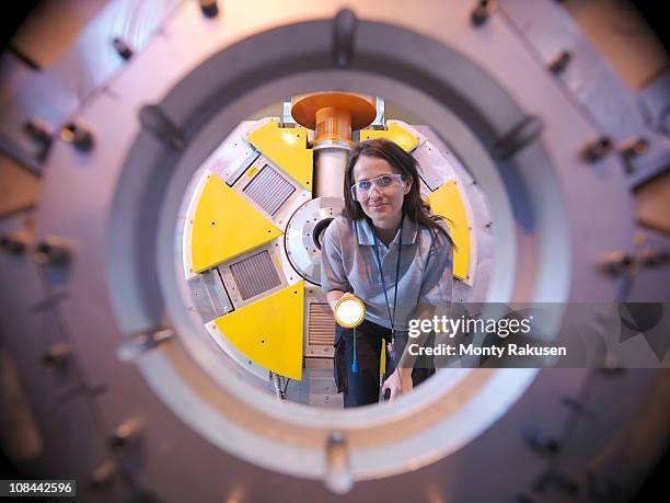 female scientist inspects particle accelerator with torch - eintracht frankfurt v fc porto uefa europa league round of 32 stockfoto's en -beelden