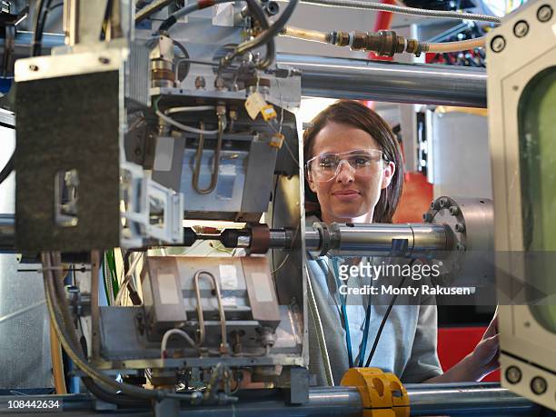 female scientist inspects particle accelerator target - teilchenbeschleuniger stock-fotos und bilder