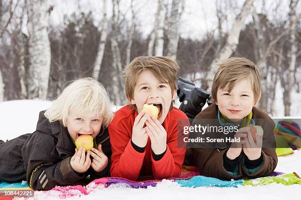 3 kids eating fruit - frost bite stock-fotos und bilder