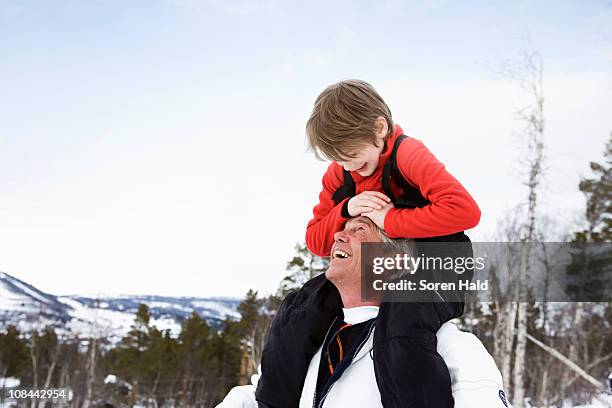 grandson and grandfather smiling - grandfather child snow winter stock pictures, royalty-free photos & images