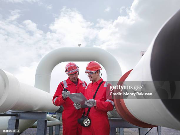 workers with pipes at gas storage plant - gas engineer stockfoto's en -beelden
