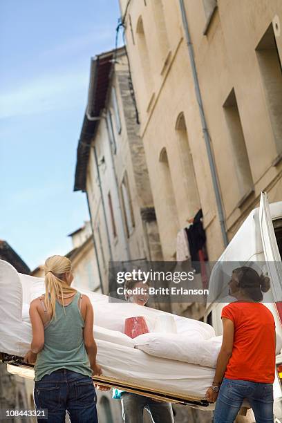 friends move couch in street - carrying sofa stock pictures, royalty-free photos & images