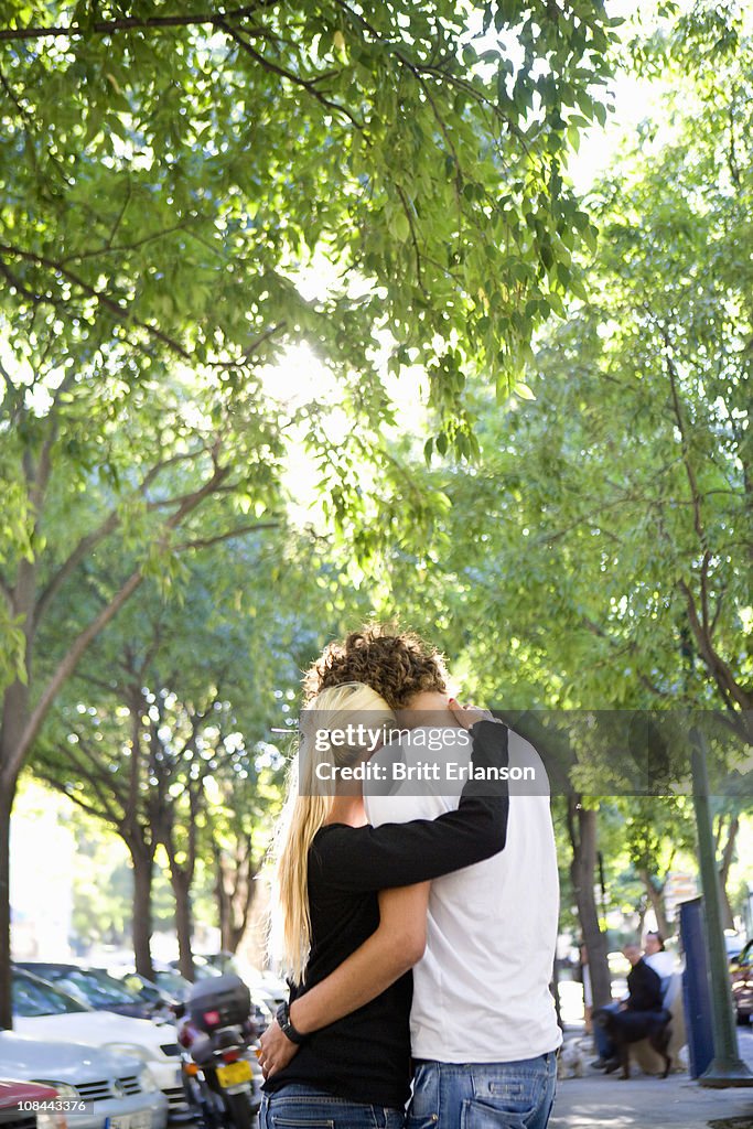 Loving young couple hug in street