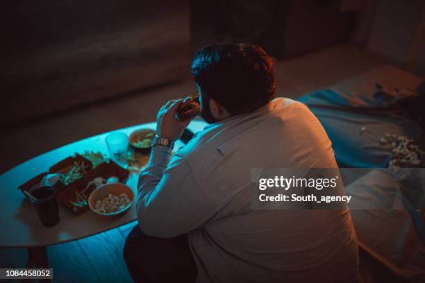 hombre con sobrepeso que comer una hamburguesa - over eating fotografías e imágenes de stock