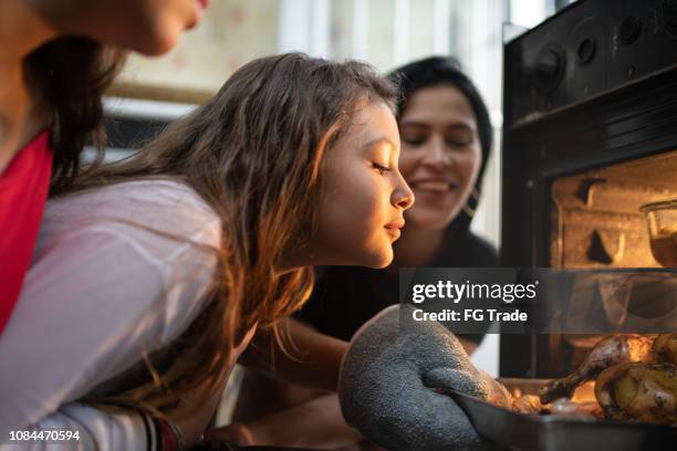 familie controleren van het traditionele turkije voor kerstdiner - oven stockfoto's en -beelden