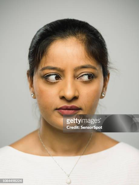 real indian young woman with blank expression looking to the side - sideways glance stock pictures, royalty-free photos & images