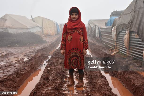 Child girl standing in the mud outside her shelter at Al-Ihsan refugee camp as Syrians enduring harsh winter at the camp in Idlib, Syria on January...