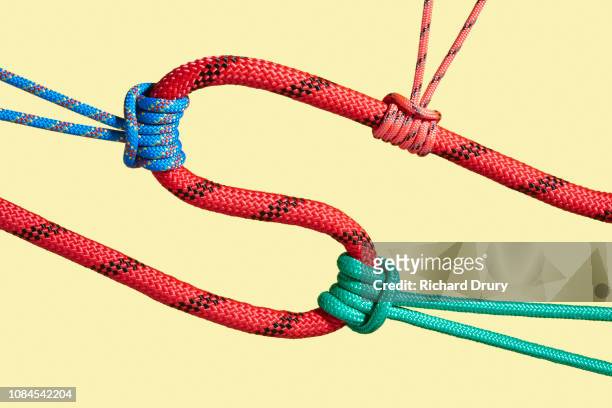 three coloured ropes pulling on a larger rope to shape its path - persuasion stock pictures, royalty-free photos & images