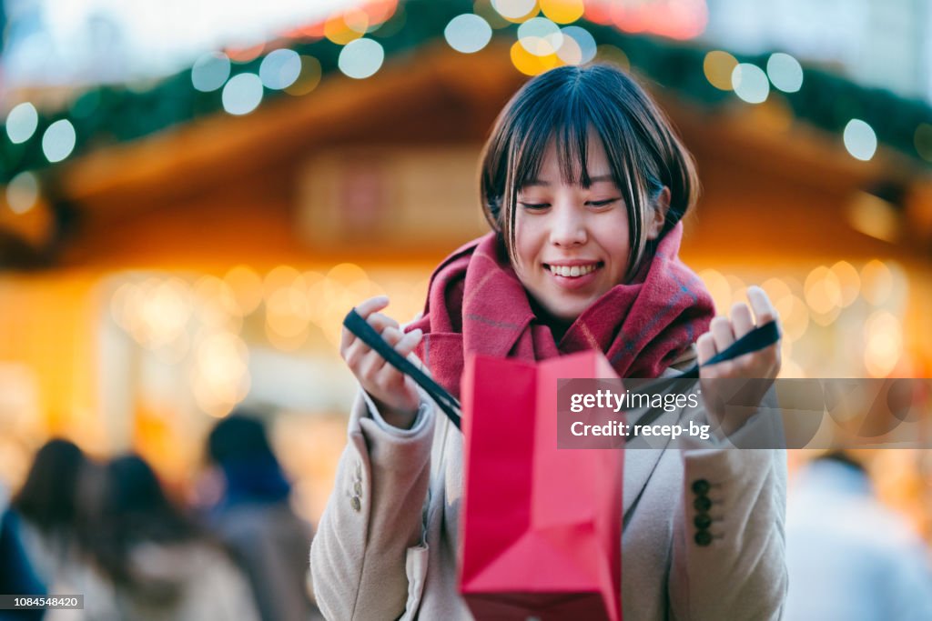 Young woman looking into shopping bag excitedly