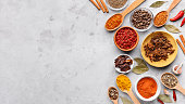 Colorful spices in spoons and bowls, top view