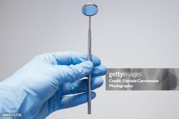 hand holding angled mirror - dental equipment stock pictures, royalty-free photos & images