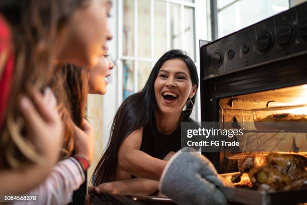 family checking the traditional turkey for christmas dinner - chicken roasting oven stock pictures, royalty-free photos & images