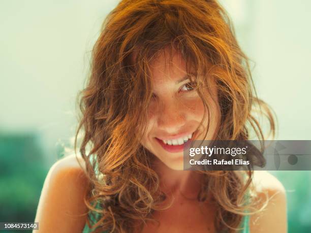 smiling young woman with messy hair - shy fotografías e imágenes de stock