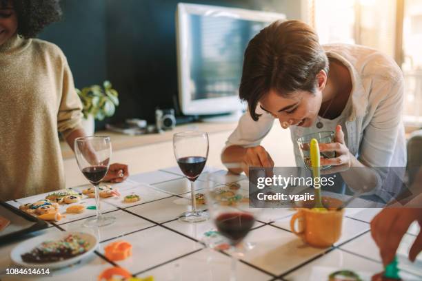 gruppe von freunden machen ingwer weihnachtsplätzchen - wein und kochen stock-fotos und bilder