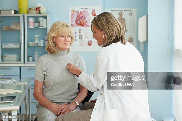 doctor using stethoscope on senior female patient - auscultation woman stock-fotos und bilder