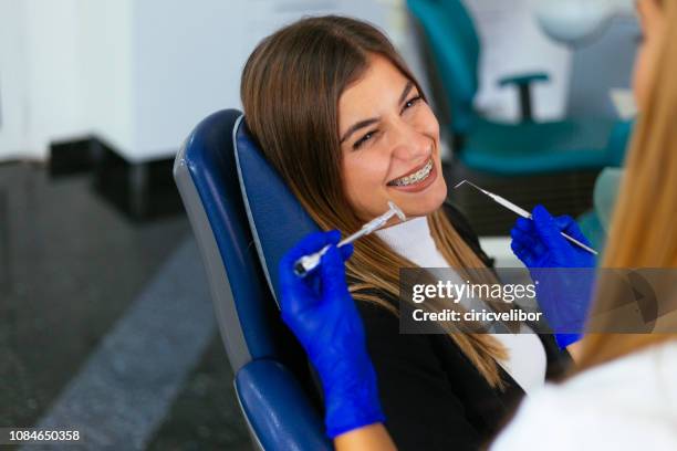 jonge vrouw bij de tandarts accolades check-up - orthodontics stockfoto's en -beelden