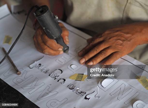 Worker sculpts inscriptions made of marble, in Bali, Indonesia on January 18, 2019. Writing on stone inscriptions is widely used to record a history,...