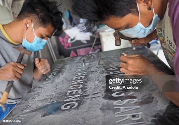 Workers sculpt inscriptions made of marble, in Bali, Indonesia on January 18, 2019. Writing on stone inscriptions is widely used to record a history,...