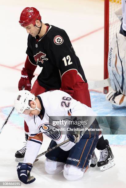Paul Bissonnette of the Phoenix Coyotes stands over Kurtis Foster of the Edmonton Oilers during the NHL game at Jobing.com Arena on January 25, 2011...