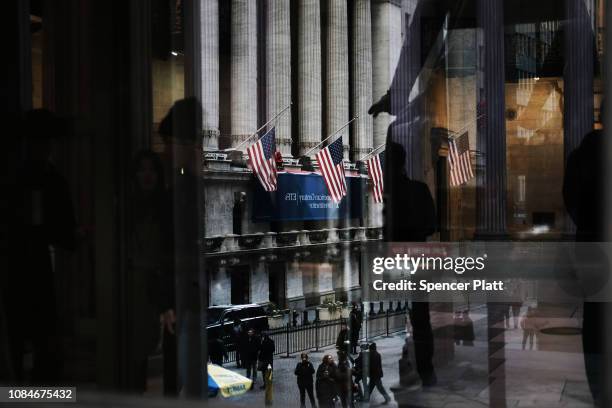 People walk by the New York Stock Exchange as the Federal Reserve Board Chairman Jerome Powell holds a news conference on December 19, 2018 in New...