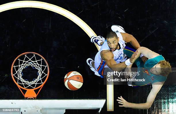 Luke Schenscher of the Crocodiles makes a jump shoit over Ira Clark of the Blaze during the round 16 NBL match between the Townsville Crocodiles and...