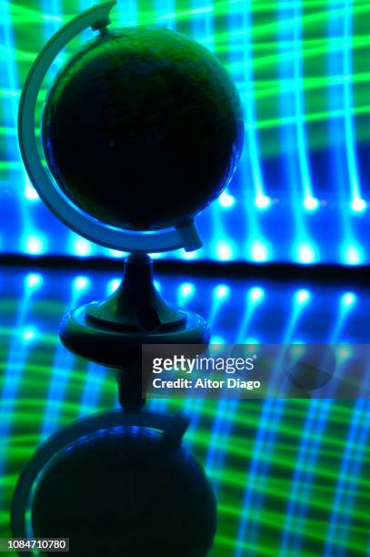 world ball on reflective surface. blue and green rays network shaped background. light painting. conceptual nature - mapa múndi imagens e fotografias de stock