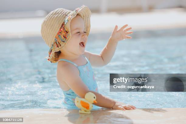 felice ragazza che ride diverte in piscina - baby in the summer foto e immagini stock