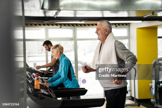 picture of people running on treadmill in gym - happy caucasian woman on elliptical trainer at gym stock pictures, royalty-free photos & images