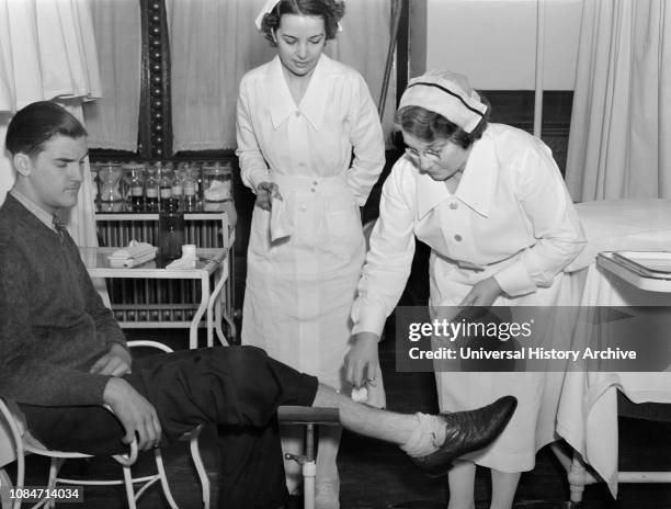 Nurse Tending to Injured Mans Wound, Public Health Service, Washington DC, USA, Carl Mydans, FSA/OWI Collection, November 1935.