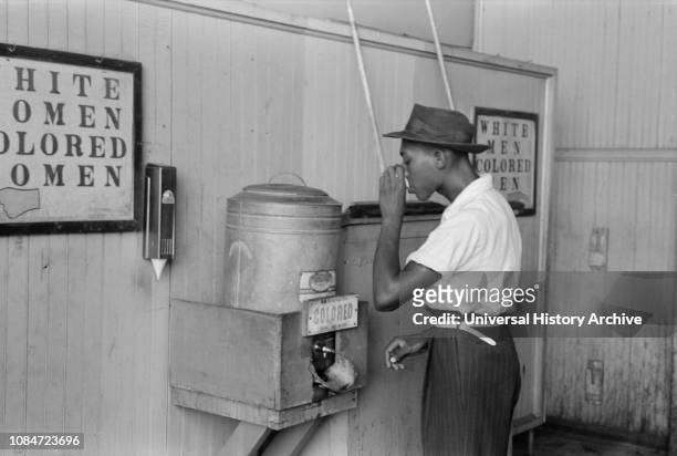 Man Drinking Water at "Colored" Water Cooler in Bus Terminal, Oklahoma City, Oklahoma, USA, Russell Lee, Farm Security Administration, July 1939.
