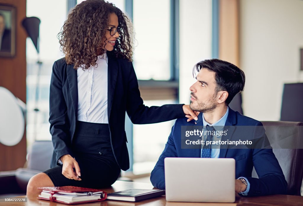 Businesswoman is flirting with her coworker in the office