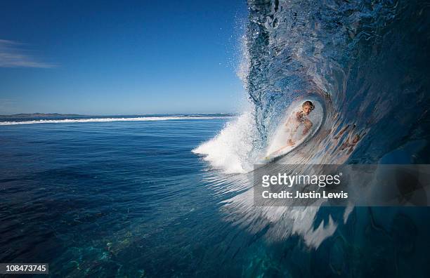 female surfer in a tube, brekaing wave - surf tube stock-fotos und bilder
