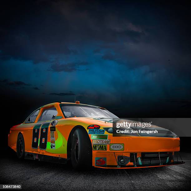 beauty shot of orange race car outside - nascar stock pictures, royalty-free photos & images