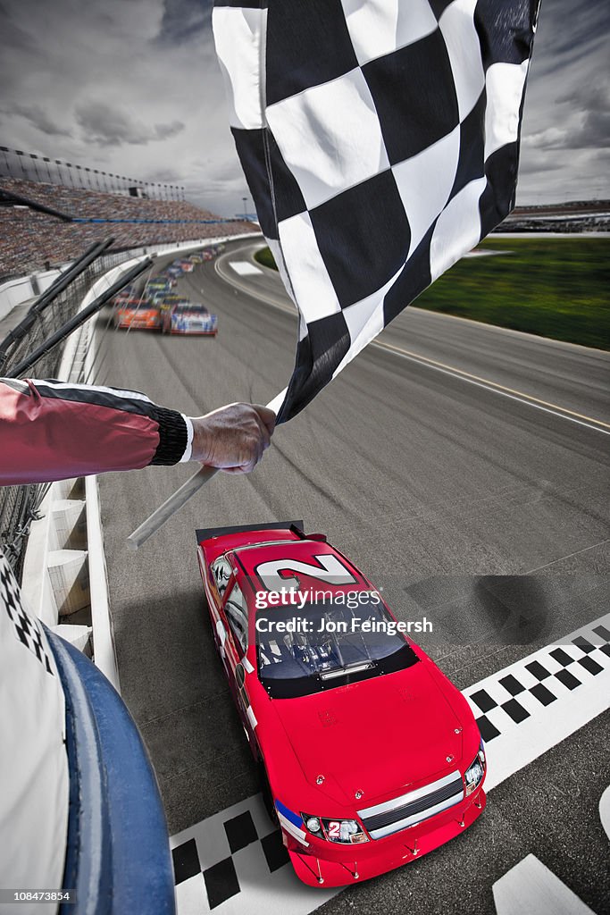Race car crossing the finish line with flag