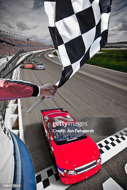 race car crossing the finish line with flag - nascar track stockfoto's en -beelden