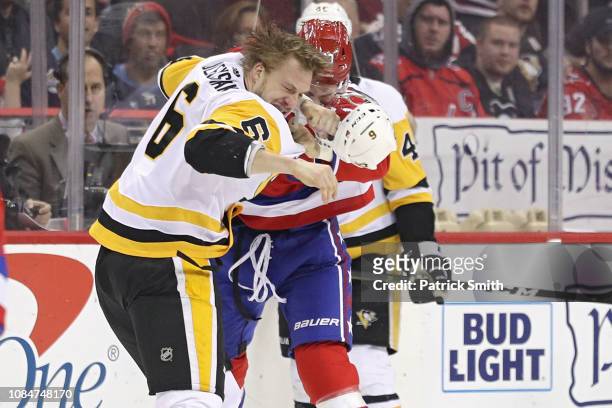 Tom Wilson of the Washington Capitals and Jamie Oleksiak of the Pittsburgh Penguins fight during the first period at Capital One Arena on December...
