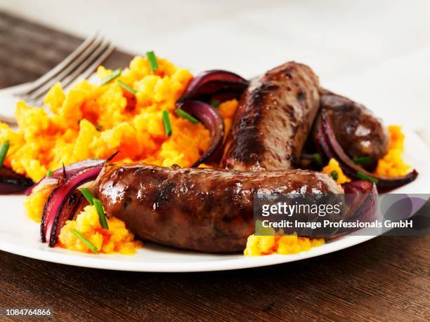sausages with mashed sweet potatoes and red onions - mashed sweet potato stock pictures, royalty-free photos & images