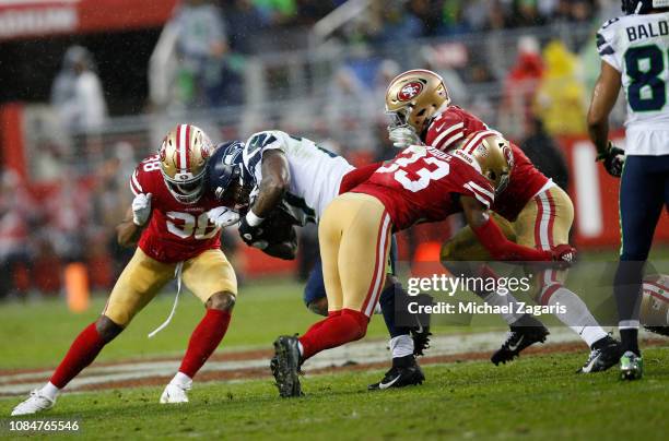 Antone Exum Jr. #38, Elijah Lee and D.J. Reed Jr. #32 of the San Francisco 49ers tackle Mike Davis of the Seattle Seahawks during the game at Levi's...