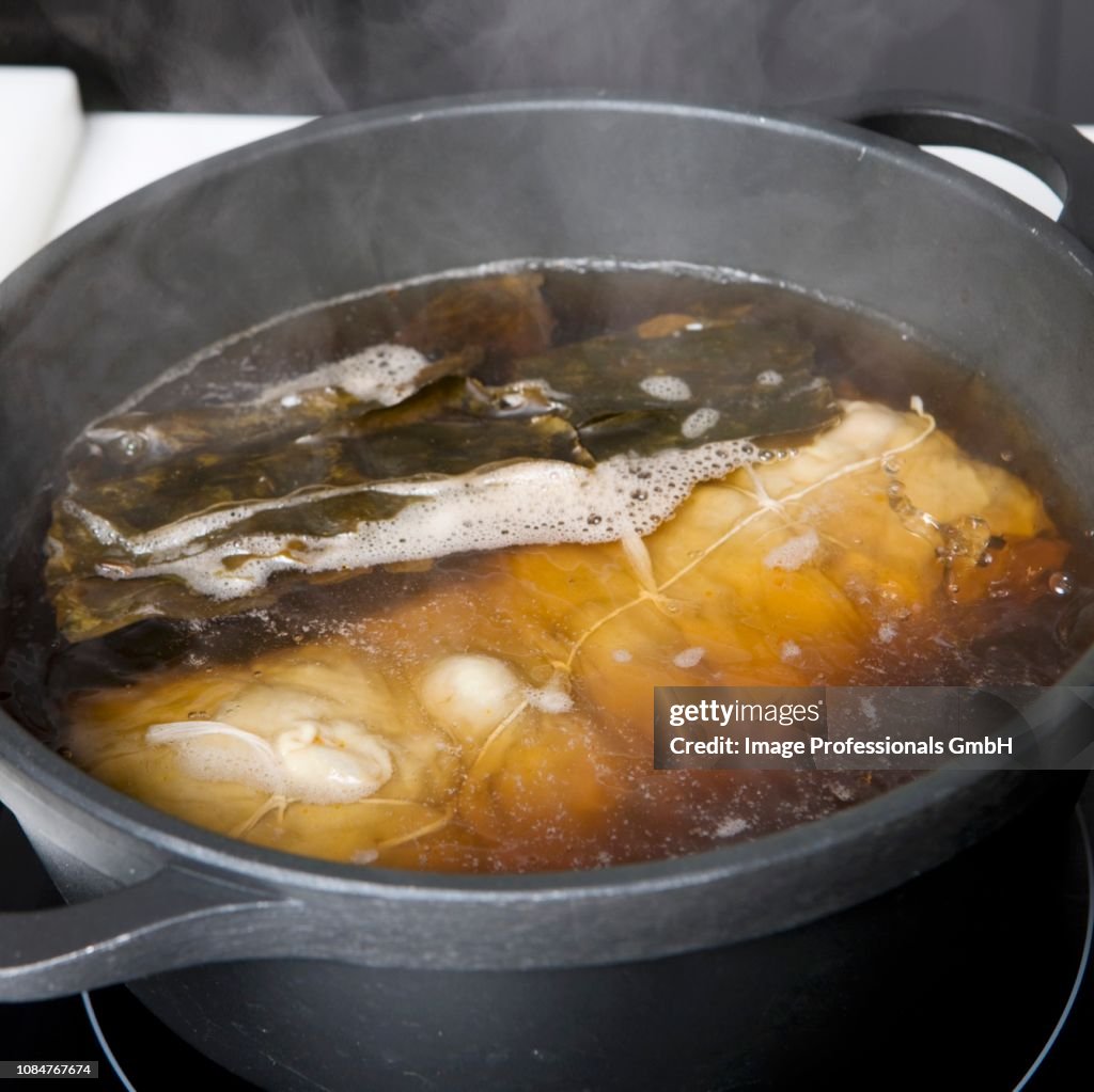 Cooking the seitan roll in a cooking pot of water and soya sauce
